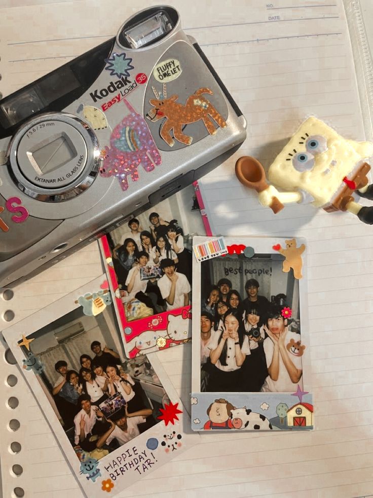 a polaroid camera sitting on top of a table next to pictures and other items