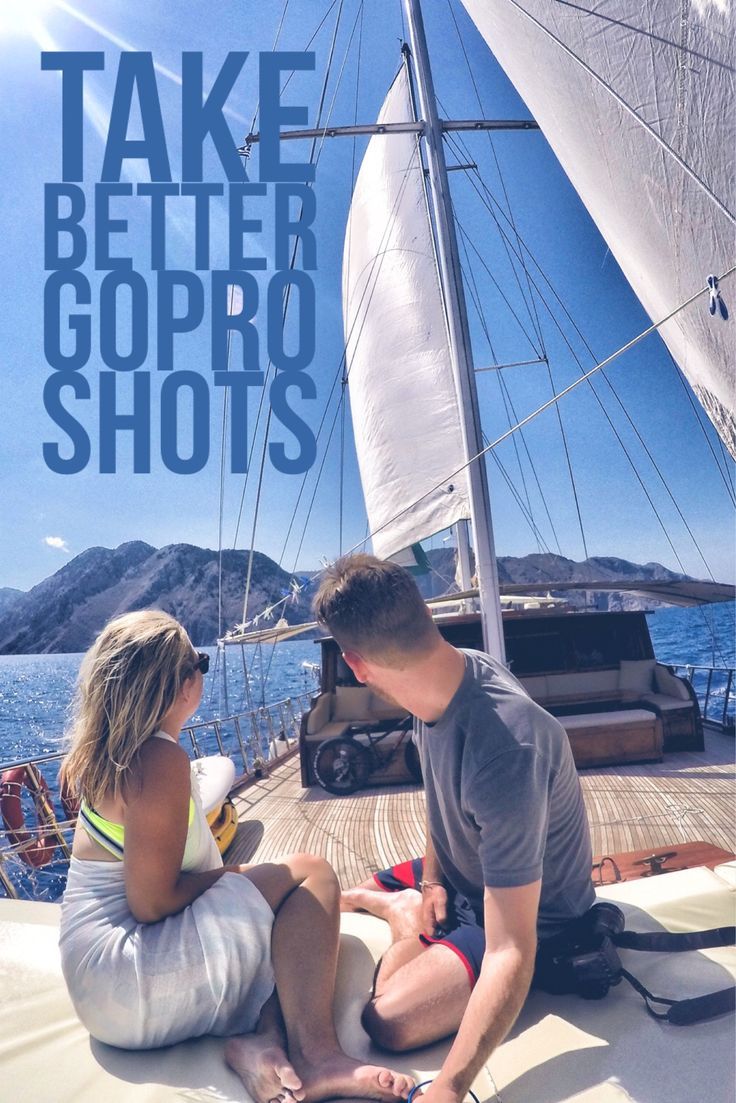 a man and woman sitting on the deck of a sailboat looking at each other