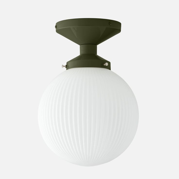 a white ball hanging from the ceiling with a green light fixture on top of it