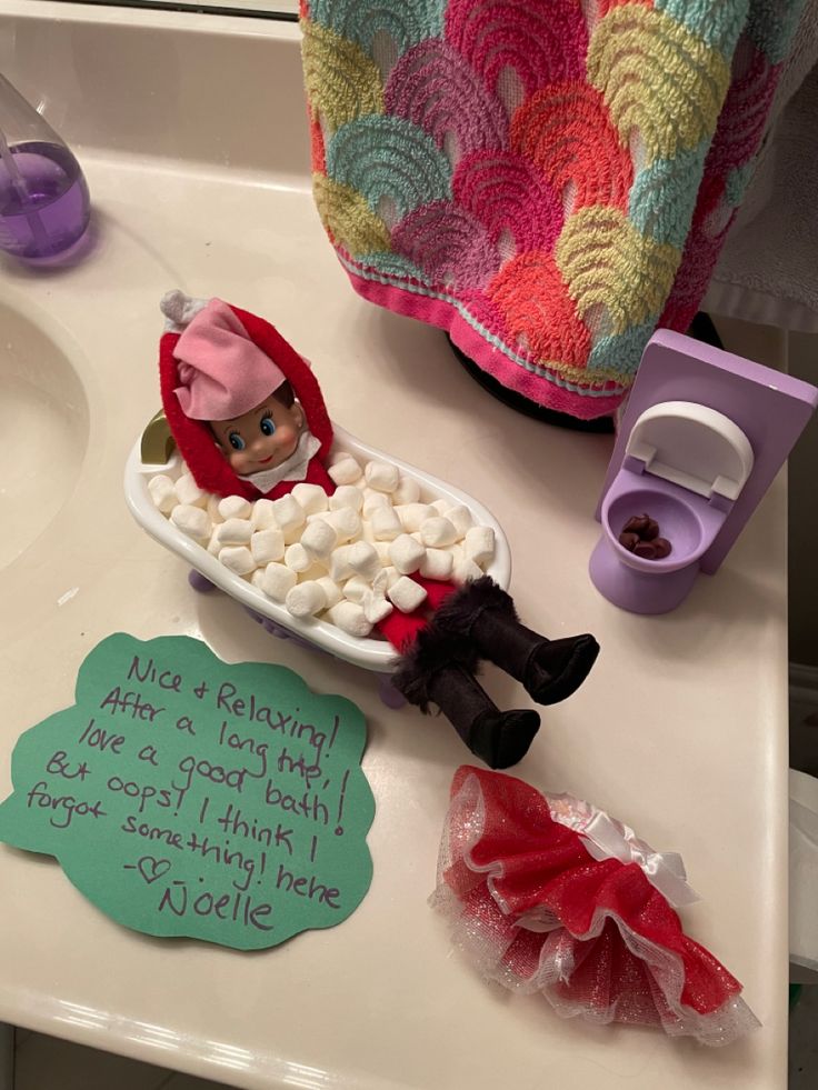 an elf is sitting in a bathtub with marshmallows on the floor