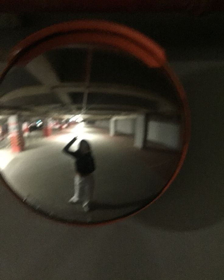 a person standing in front of a round mirror