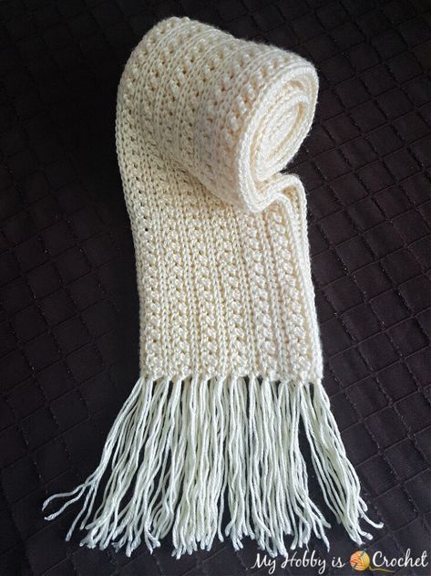 a white knitted scarf with fringes