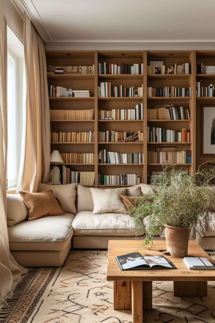 a living room filled with lots of bookshelves next to a couch and coffee table