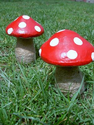 two red and white mushrooms sitting in the grass