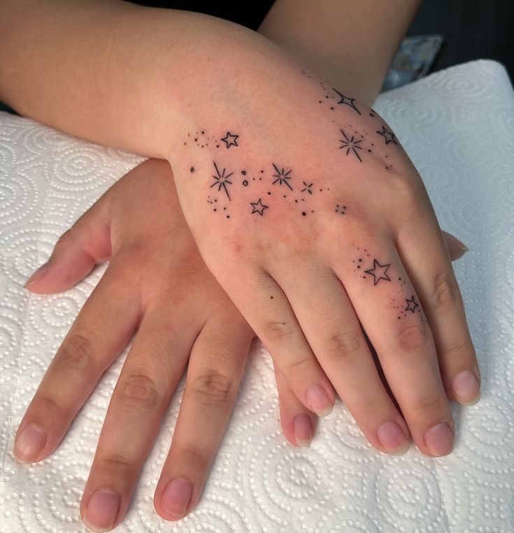 a woman's hand with stars tattooed on it