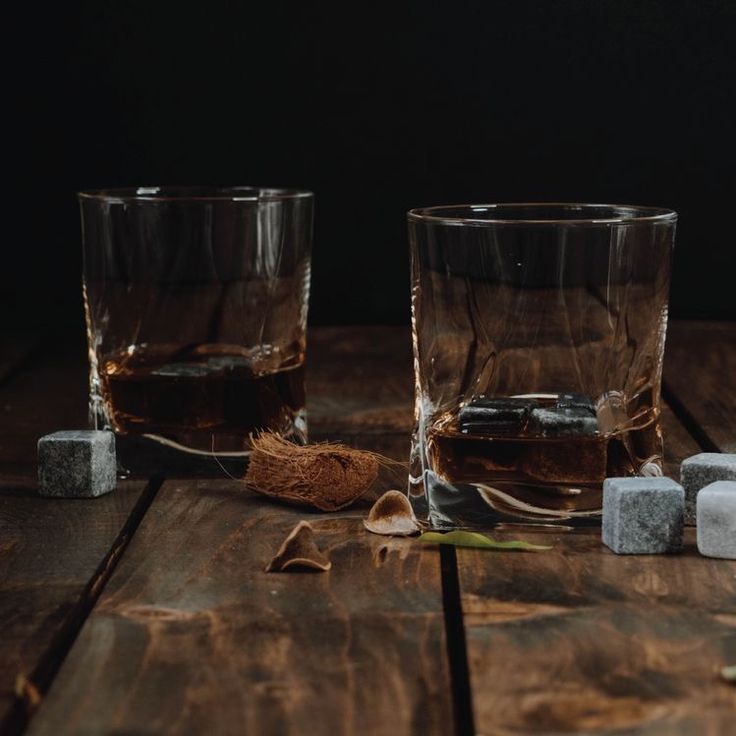 two glasses with ice cubes next to each other