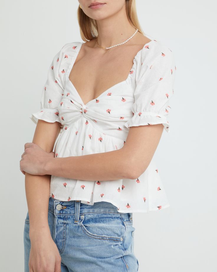 Price Comparison Few Moda $54 For Love & Lemons $138 Alice + Olivia $168 Product Details The fitted bust and relaxed body of this adorable blouse guarantees a flattering fit. Finished with embroidered floral details for an elevated touch.- Back smocking- Content: 90% Cotton, 10% Linen Style# K22WTP20156 Fit Notes - Model wearing a size XS- Shoulder seam to hem measures approx 19.5'' in length - Model measurements: 5'10.5'' Height / 32'' Bust / 25.5'' Waist / 34.5'' Hips Flirty Fitted Top For Brunch, Flirty Top For Brunch, Spring Floral Embroidered V-neck Top, Fitted Cotton Flirty Tops, Fitted Flirty Cotton Tops, Feminine Fitted V-neck Blouse, Summer Floral Embroidered Tops For Day Out, Chic Fitted Tops With Floral Embroidery, Summer Floral Embroidery Tops For Day Out