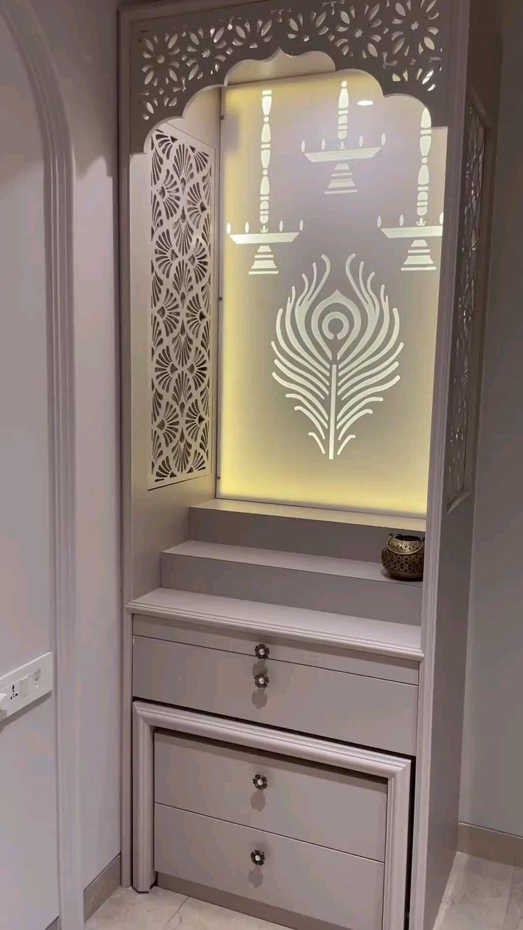 a white cabinet with drawers and an intricate laser cut design on the front door is shown