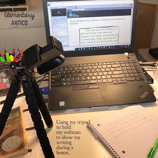 an open laptop computer sitting on top of a desk next to a camera and notebook