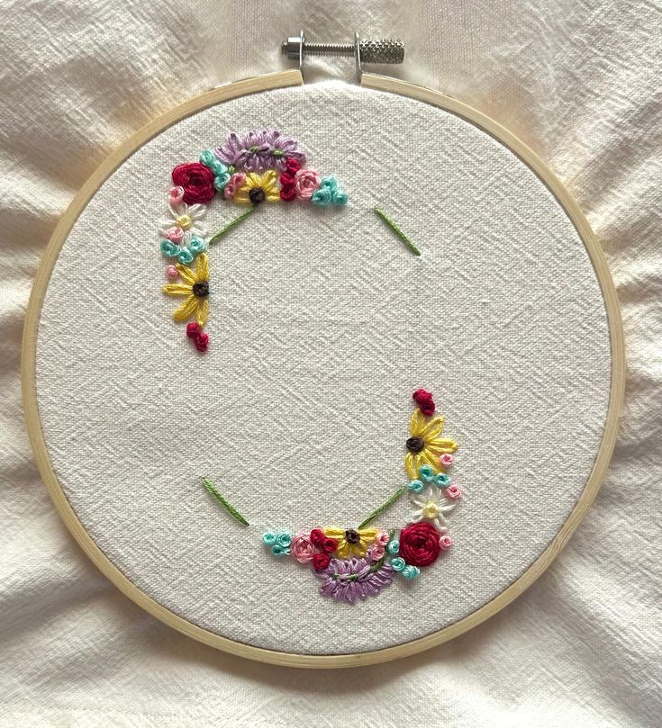 the embroidery is being worked on by someone using scissors and thread to make it look like an o