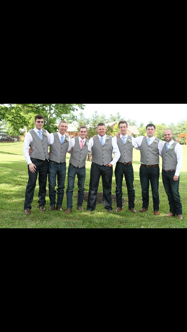 a group of men standing next to each other on top of a lush green field