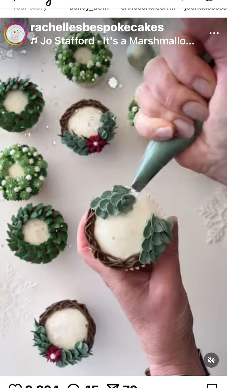 someone is decorating some cupcakes with icing and greenery on them