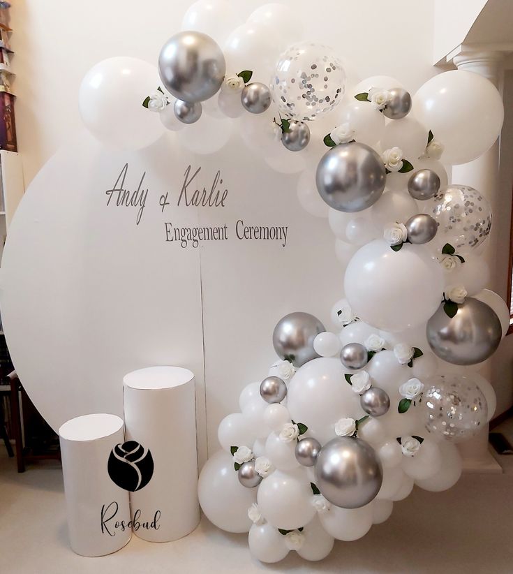 an arrangement of white and silver balloons on display