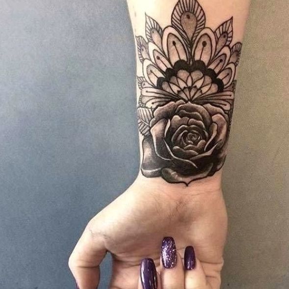 a woman's hand with a flower tattoo on it