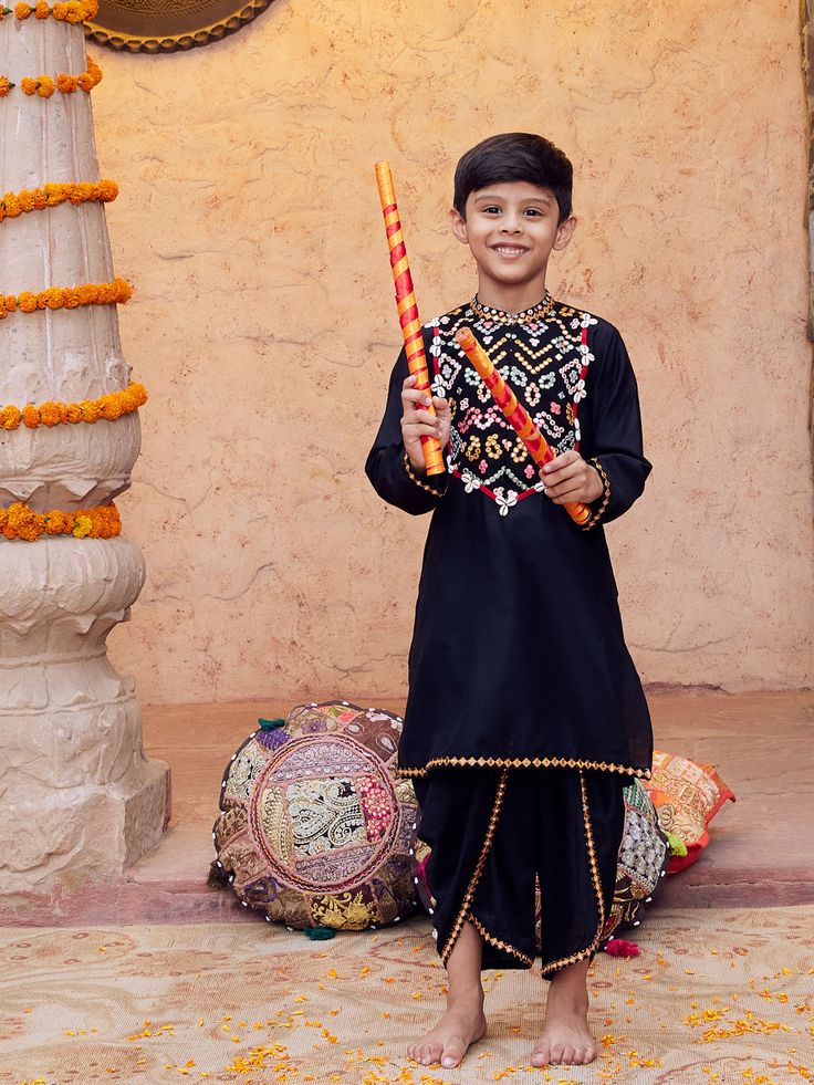 VASTRAMAY Boys' Black Navratri Special Embroidered Dhoti Kurta Set A perfect attire for your little one this Navratri season! This black dhoti kurta set features intricate embroidery, offering a traditional yet stylish look. Made with high-quality fabric, it ensures comfort and elegance. Features: Intricate embroidery Comfortable fabric Traditional design Specifications: Color: Black Size: Boys' Occasion: Navratri Special Material & Care: Material: Cotton Care: Hand wash or machine wash with gen Festive Dabka Choli For Festivals, Sherwani With Dori Work For Navratri Puja, Navratri Sherwani With Dori Work For Puja, Dabka Sets For Puja And Festivals, Festival Dabka Sets For Puja, Festive Traditional Wear With Resham Embroidery For Rituals, Festive Sets With Resham Embroidery For Rituals, Traditional Sharara With Dabka For Festivals, Black Sherwani With Zari Work For Navratri