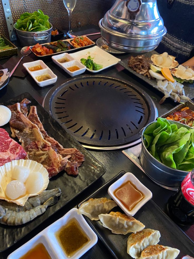 an assortment of meats, vegetables and sauces on trays