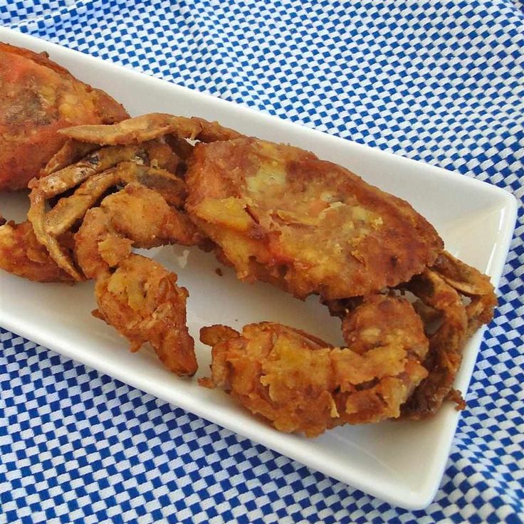 some fried food on a white plate on a blue and white checkered table cloth