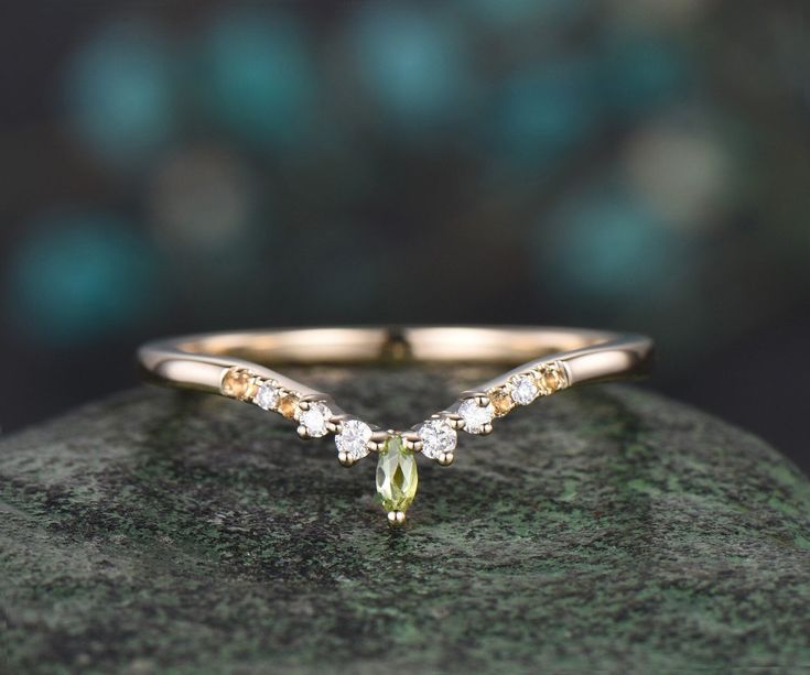 a yellow diamond ring sitting on top of a rock