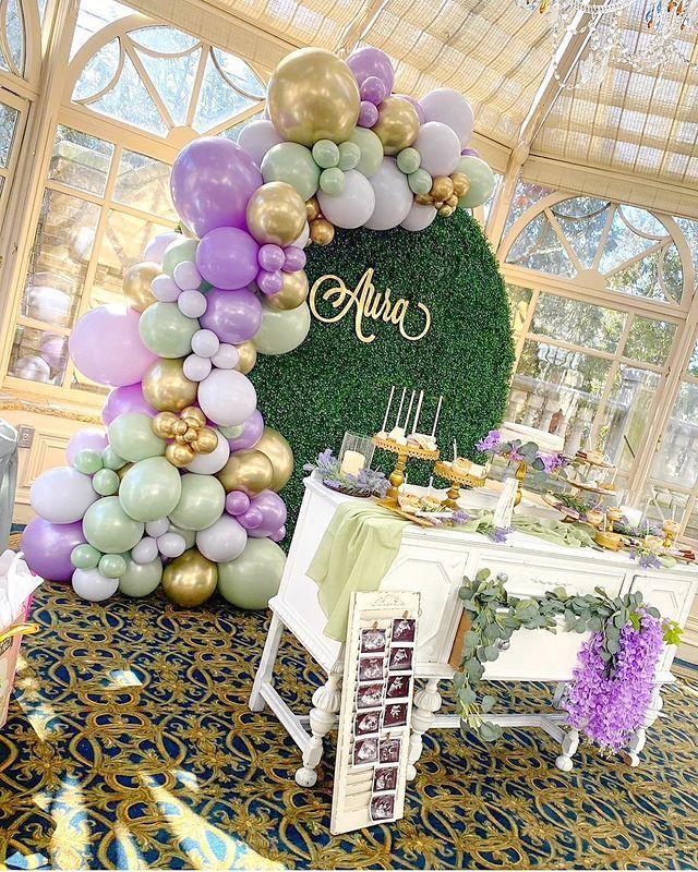 a table topped with lots of balloons next to a wall