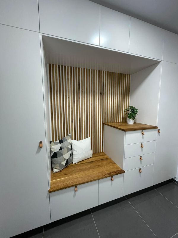 a room with white cupboards and wooden counter tops on the wall, along with a plant