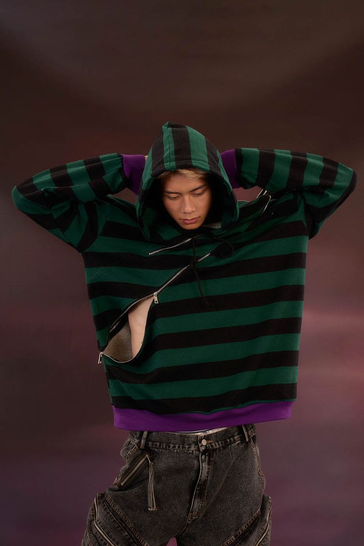 The Diagonal Zipped Striped Hoodie perfectly captures a fusion of retro vibes and streetwear style, making it a standout addition to any casual wardrobe. This hoodie is adorned with dual-tone horizontal stripes, adding a vibrant and dynamic element to the classic hoodie design. It features two diagonal zippers that can be opened to create custom openings, enhancing both the visual appeal and the practicality of the garment. The hoodie is designed with contrasting color patches at the cuffs and h Urban Streetwear Sweatshirt With Zipper, Urban Streetwear Sweatshirt With Zipper Closure, Streetwear Long Sleeve Sweatshirt With Zipper, Urban Zipper Sweatshirt For Streetwear, Long Sleeve Sweatshirt With Zipper For Streetwear, Winter Streetwear Half-zip Hoodie, Winter Half-zip Hoodie For Streetwear, Urban Hoodie With Ykk Zipper For Streetwear, Urban Sweatshirt With Ykk Zipper For Streetwear