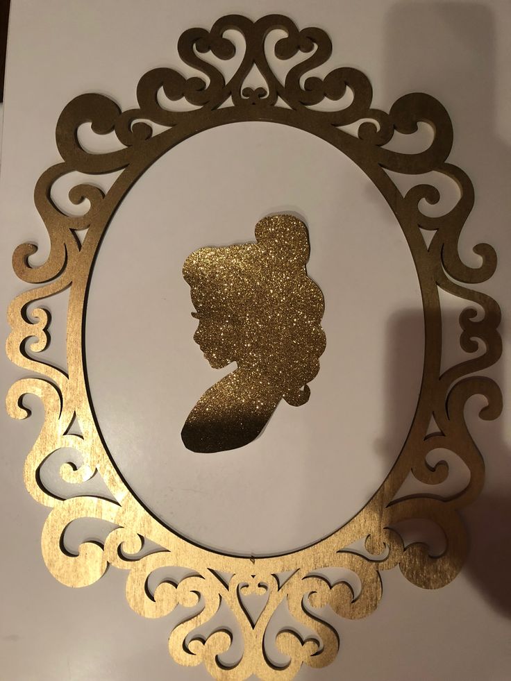 an ornate gold frame with a silhouette of a woman's head in the center