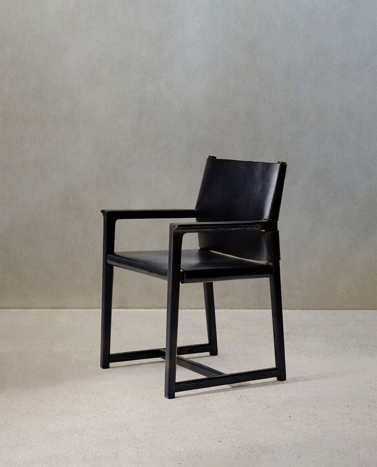 a black chair sitting on top of a white floor