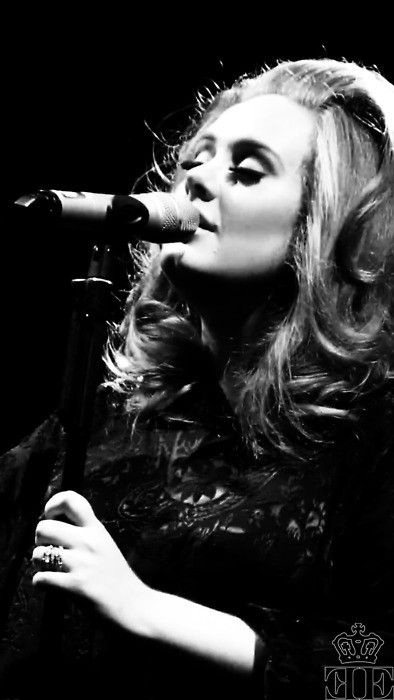 a black and white photo of a woman singing into a microphone with her eyes closed