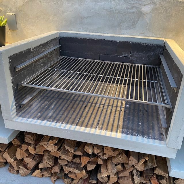 an outdoor fire pit made out of cinder blocks and wood stacked on top of each other