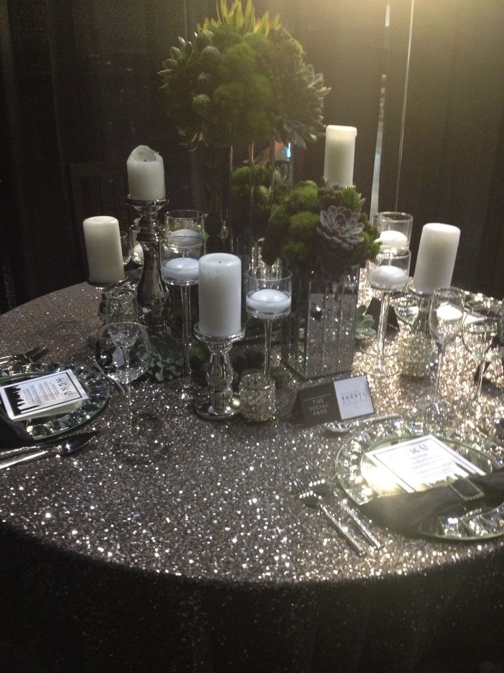 the table is set with silver sequins and candles