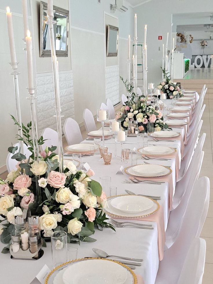 a long table is set with white and pink flowers