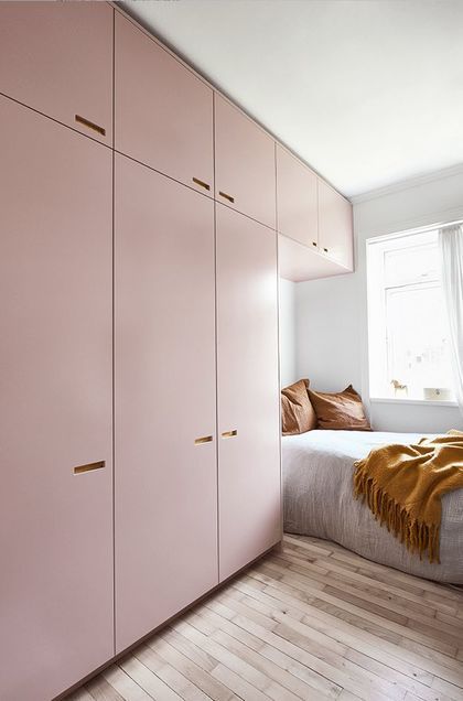 a bedroom with pink cabinets and white walls