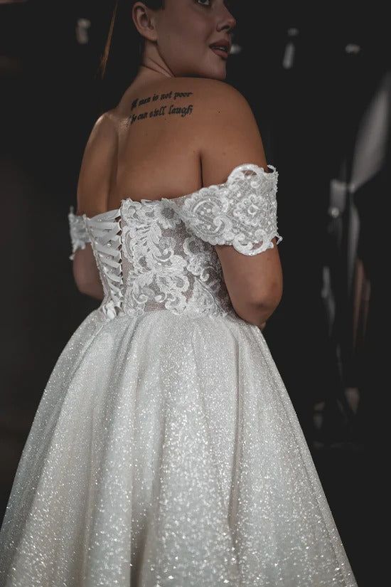 a woman in a white dress with tattoos on her back