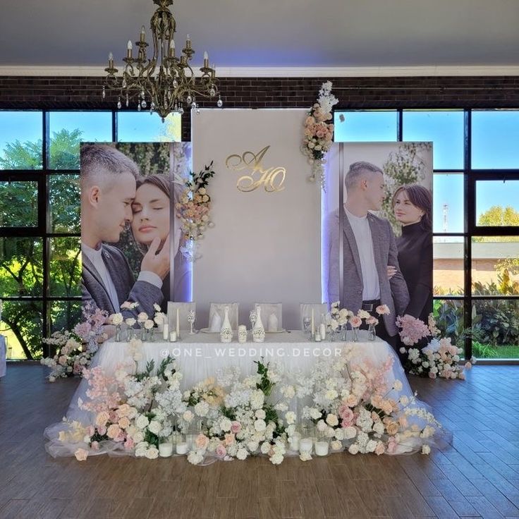 a table with flowers and candles on it in front of two pictures that say mr and mrs