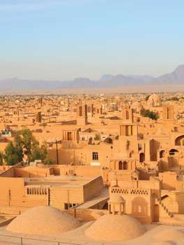 an aerial view of the desert city of djennen, with mountains in the background