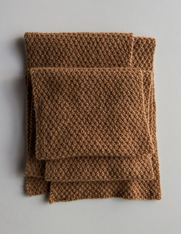 two pieces of brown knitted cloth on top of each other, one folded and the other unbuttoned