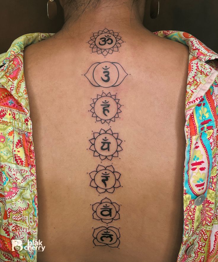 the back of a woman's neck with seven chakras on it