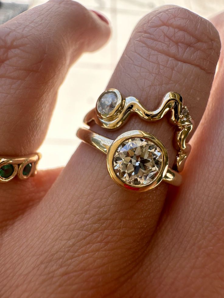 a woman's hand with two different rings on it