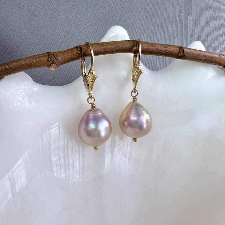 "✦These large and beautifully paired freshwater Edison pearl earrings have a beautiful luster and baroque flame ball shape, with iridescent blush pink or dusty rose color.  The pearls are wire wrapped to 14k gold filled lever back ear wires. The freshwater pearls measure 11mm in diameter and total length is a little less than 1.5\" in length. ✦Available with your choice of 14k gold filled French hook, Fleur de Lis or plain leverback ear wires. Please select at check out. ✦Click here to see these earrings in sterling silver: https://www.etsy.com/listing/1650340050 ✦What is an Edison Pearl? An Edison pearl is a type of freshwater cultured pearl known for its large size, lustrous surface, and unique colors. These pearls are cultivated using a technique that involves grafting a small piece of Freshwater Mussels, Pink Pearl Earrings, Brazilian Gold, Diy Jewelry Projects, Edison Pearls, Saltwater Pearls, Lavender Pink, Dusty Rose Color, Leverback Earrings