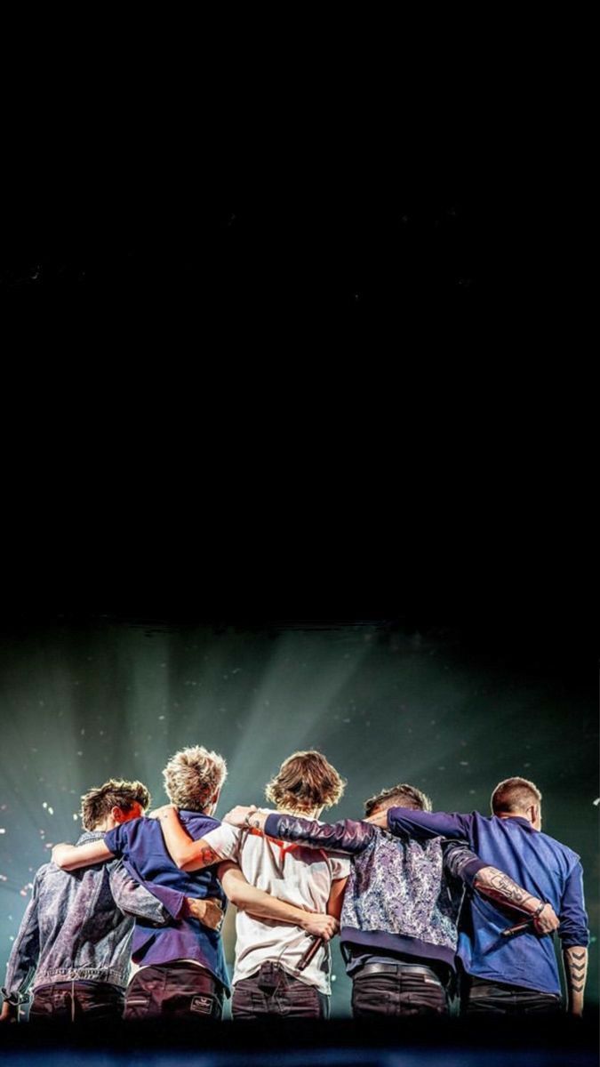 a group of young men standing next to each other on top of a blue stage