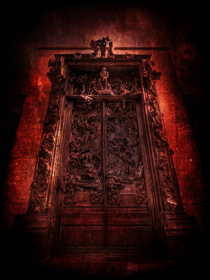 an old wooden door with carvings on the front and sides, lit up by a red light