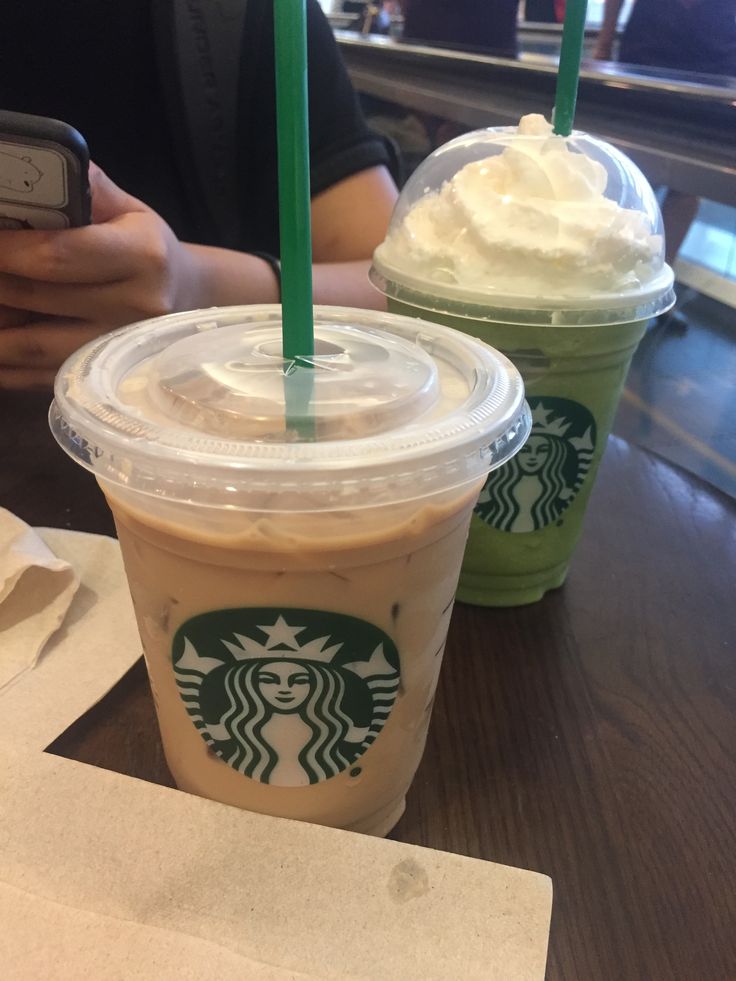 two starbucks drinks sitting next to each other on a table