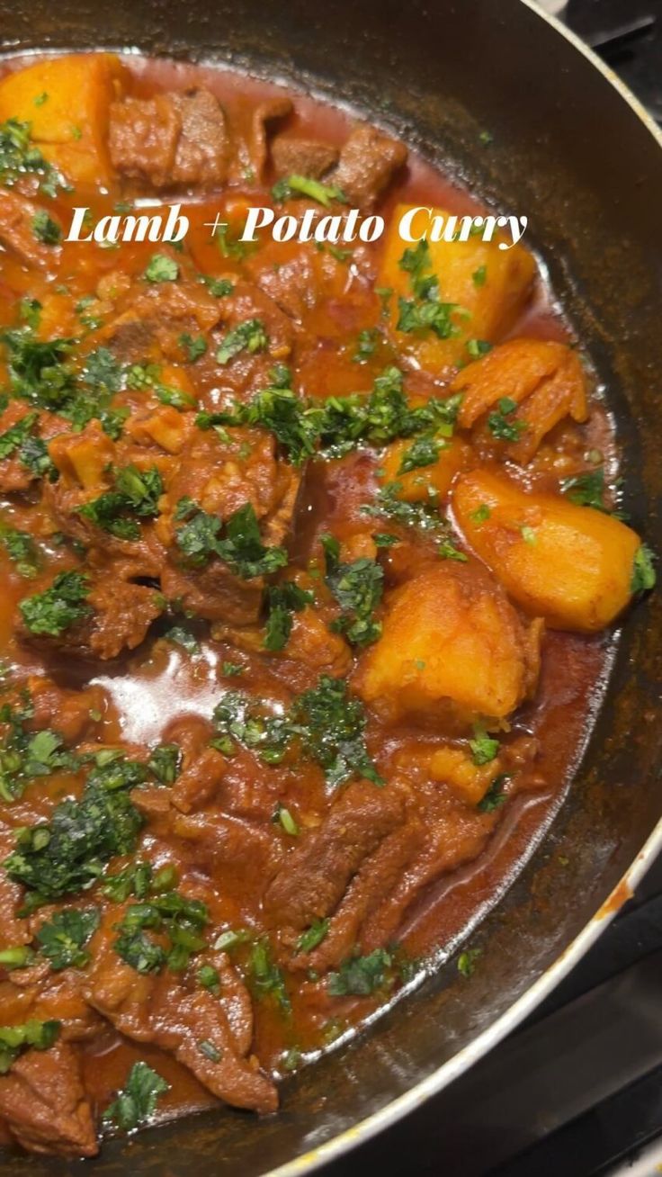 lamb and potato curry in a skillet with parsley on the top, ready to be eaten