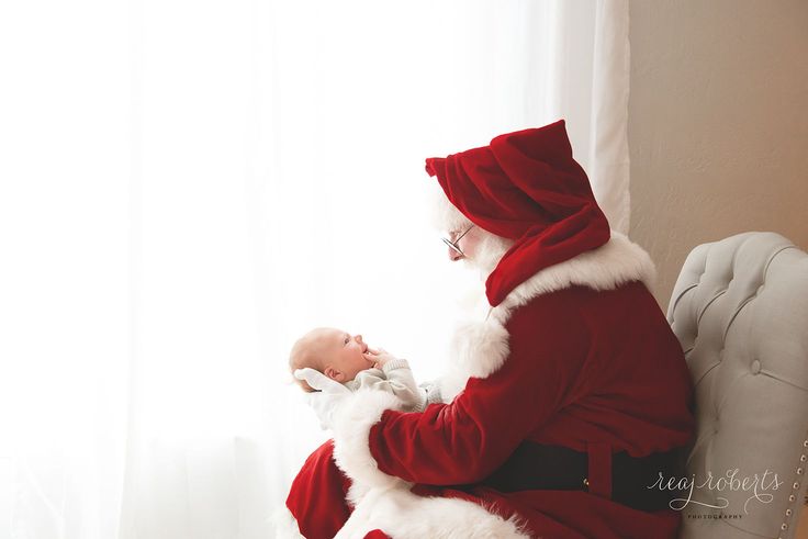 a man dressed as santa claus holding a baby