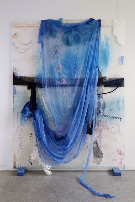 an art piece with blue fabric hanging from it's sides