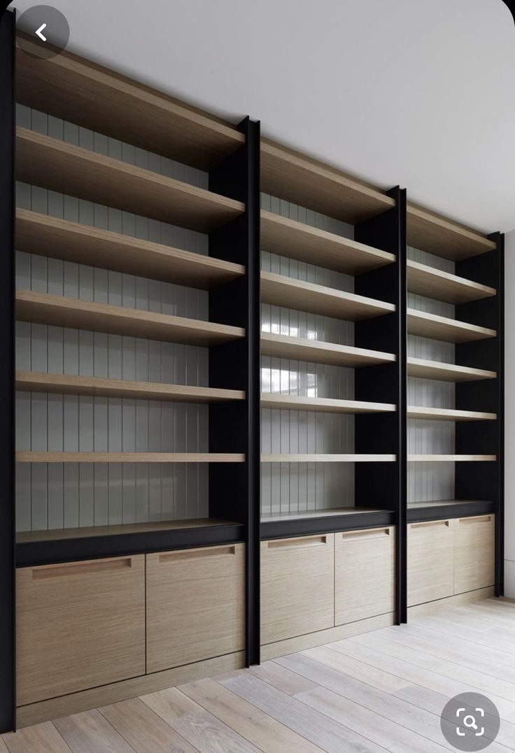 an empty room with wooden shelves and glass doors on the wall, in front of a wood floor