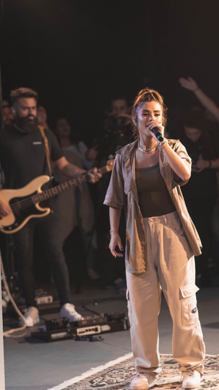 a woman standing on top of a stage holding a microphone