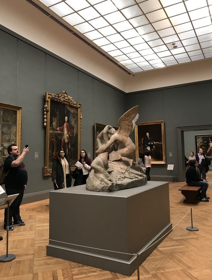 a group of people taking pictures of some art