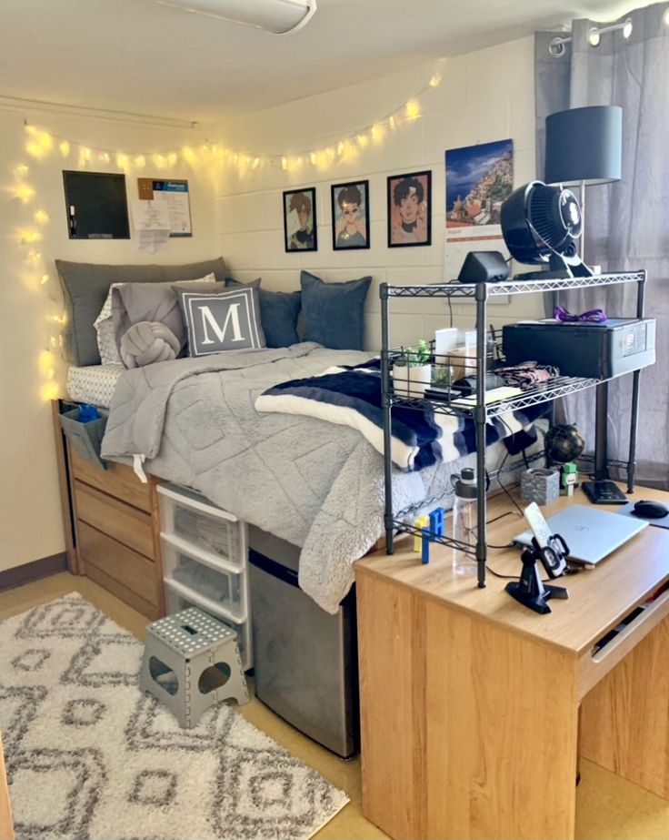 a dorm room with a bed, desk and other items on the table in front of it