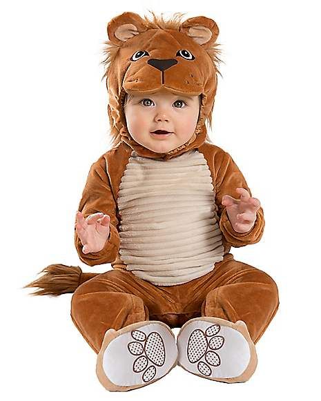 a baby dressed in a lion costume sitting on the ground with his hands up and eyes closed